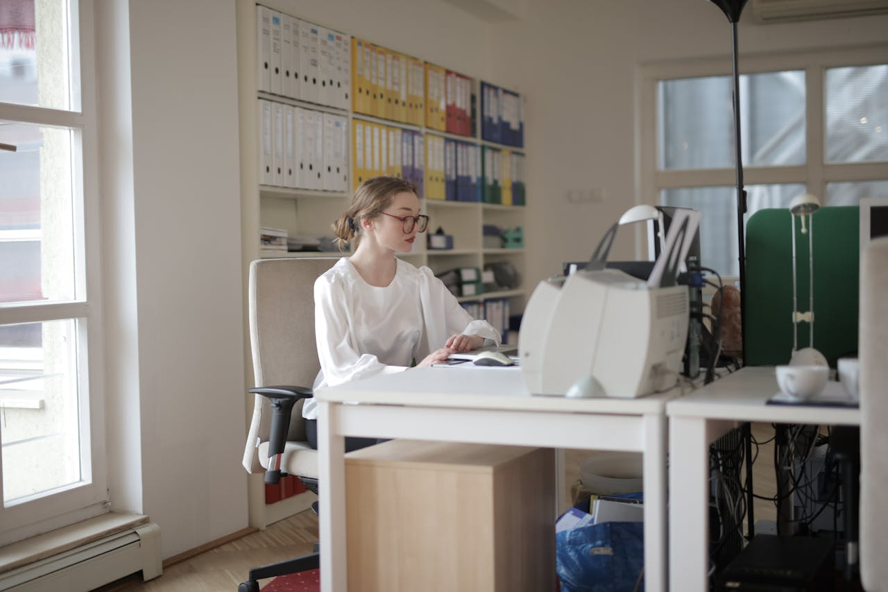 Mastering the First Impression: Your intriguing post title goes here Focused woman working in a modern office filled with files and equipment.